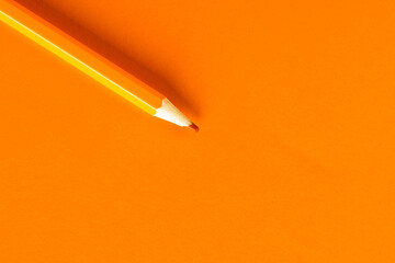 Close up of orange pencil with copy space on orange background