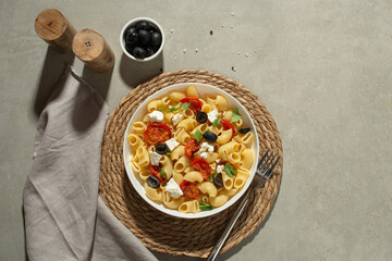 Pasta salad with dried tomatoes, cheese and olives