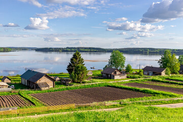 Top view of an idyllic rural landscape. Lake, village house, vegetable garden and boat
