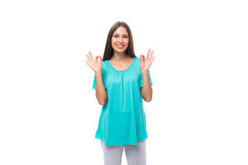 young caucasian female model with black straight hair is wearing a blue t-shirt on a studio white background with copy space