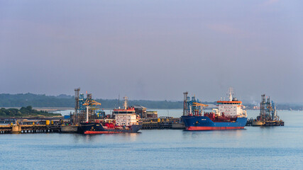 Fototapeta premium Sunrise over Gas Ships and Esso Oil Terminal, Southampton, Hampshire, England