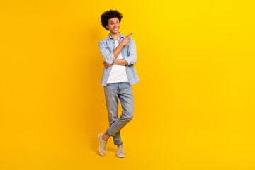 Full size portrait of cheerful nice man indicate finger empty space offer isolated on yellow color background