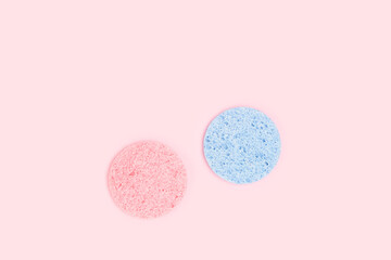 Obraz na płótnie Canvas Face wash sponges on a pink pastel background.