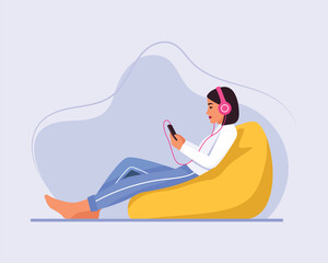 light-skinned girl with short hair sits on a bag chair with a headphones