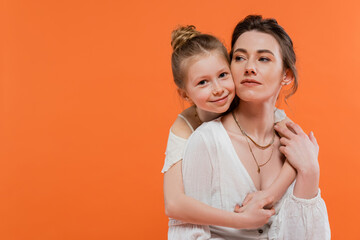 mother and daughter, cheerful preteen girl hugging young woman on orange background, white sun dresses, modern parenting, summer fashion, togetherness, love