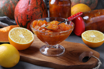Homemade pumpkin jam with lemon and orange in transparent bowl and in jars - obrazy, fototapety, plakaty