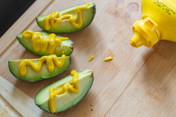 Avocado cut up with mustard on it, copy space backgrounds food and drink theme