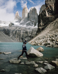 girl jumping on rocks at torre del paine, patagonia