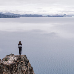 girl on a cliff with a huge lake in the background