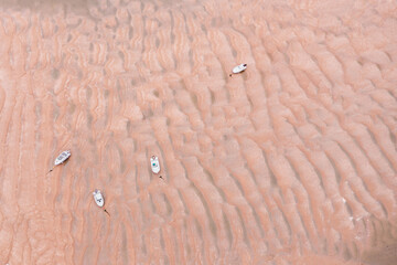 Des petits bateaux de plaisance échoués sur un banc de sable à marée basse en normandie - obrazy, fototapety, plakaty