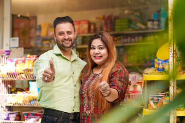 Indian couple showing thumps up at grocery shop.