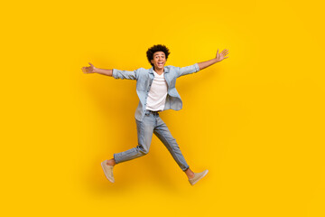 Fototapeta na wymiar Full body portrait of excited carefree person jumping flight have good mood isolated on yellow color background