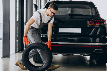 Naklejka na ściany i meble Mechanic changing tires in a car service