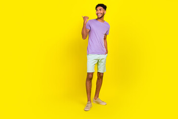 Fototapeta na wymiar Full length body photo of young advertiser man pointing finger empty space wear trendy apparel summer sale isolated on yellow background