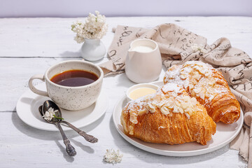 Good morning concept. Breakfast with cup of coffee and fresh croissant. Sweet creamy sauce