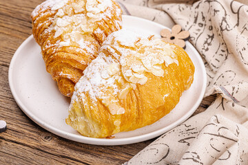 Good morning concept. Fresh croissants with cream filling and almond flakes. Sweet dessert