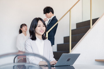 フリーアドレスのオフィスで働くビジネスウーマン