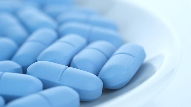 Heap of Blue pills close up, rotation. Pharmaceutical Industry. The medicine concept