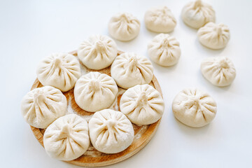 Khinkali sprinkled with flour on round wooden board