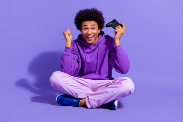 Full length photo of overjoyed impressed guy dressed violet hoodie hold joystick win playstation game isolated on purple color background © deagreez