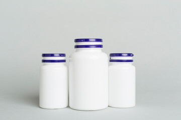 Plastic bottles for vitamins on color background