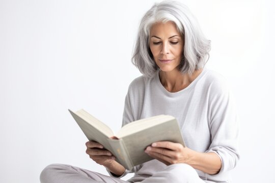 Lifestyle portrait photography of a tender mature woman reading a book against a white background. With generative AI technology