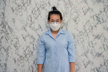 Woman puts on a face mask standing with crossed arms protecting from virus during quarantine isolated on White background,pandemic and social distancing concept