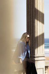 A girl posing between columns.