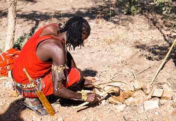 Maasai warrior using traditional tools