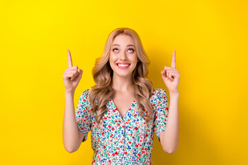 Portrait of stunning positive lady wear trendy clothes arms demonstrate empty space nice proposition isolated on yellow color background
