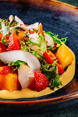 Shrimps salad with arugula, mango and coconut in bowl