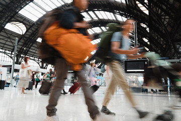 People walk at the central train station in Milan