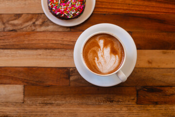 Delicious cappuccino with beautiful foam and donut flatlay