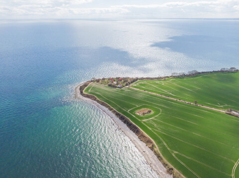 Paradiesinsel aus der Vogelperspektive: Luftaufnahme von Fehmarn mit Felderlandschaft, blauem Meer, Leuchtturm, Strand, Wellen und Windr&auml;dern