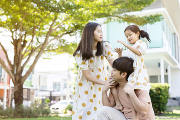 asian family Parents and daughters doing a happy walk in the village garden. During the holidays weekends to relax. friendship and living together. member health care. Concept health insurance