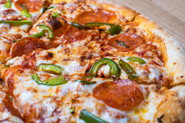 freshly prepared pizza with cheese sausage and green pepper