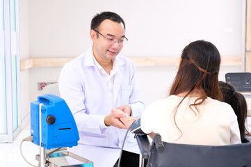 Fototapeta premium Asian male doctor measuring blood pressure for a female patient.