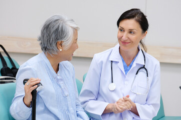 female doctor with old female patient smiling.