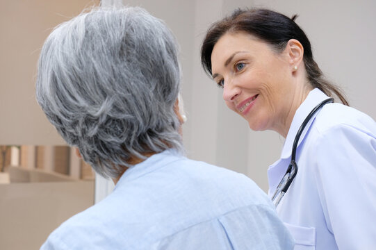 female doctor with old female patient smiling.