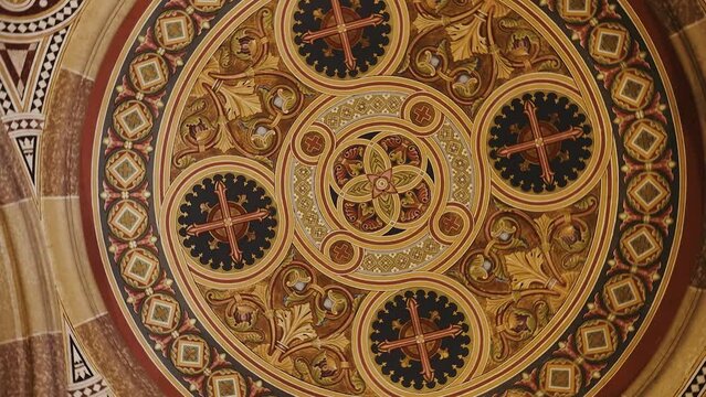 The ceiling of a historical architectural building with symmetrical patterns. Geometric drawings on the ceiling of the church. The dome of the church.