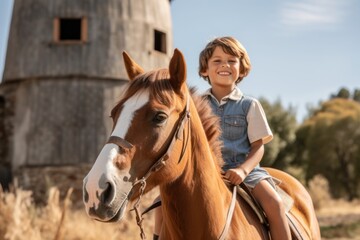 Obraz premium Medium shot portrait photography of a happy kid male riding a horse against a rustic windmill background. With generative AI technology