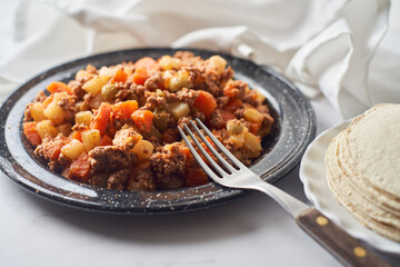 Picadillo, stew popular in Mexico and Latin America made with meat, carrots, potatoes and olives.