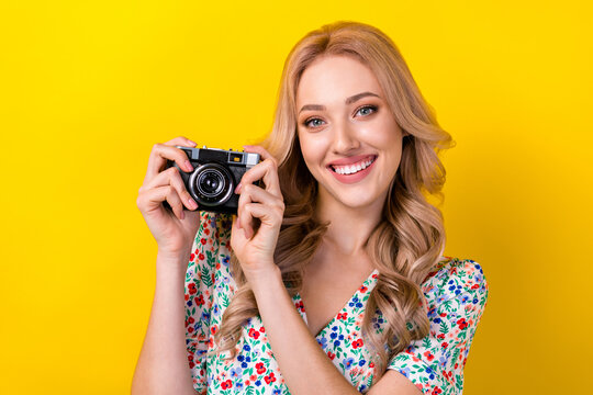 Photo of positive gorgeous cute lady wear trendy clothes buy new quality camera walk make picture isolated on yellow color background