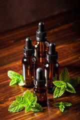 fresh mint Peppermint herb leaves essential oil in dropper bottles © Olga Miltsova