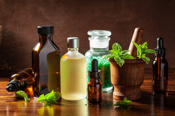 fresh mint Peppermint herb leaves in mortar and essential oil in dropper bottles