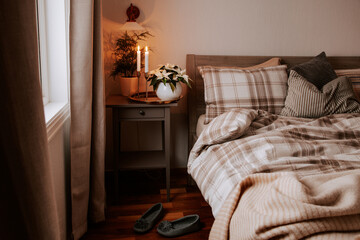cozy scandinavian bedroom interior in natural tones, blanket candles houseplants