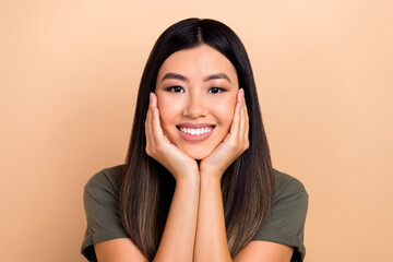 Closeup photo of cute asian girl hold arms hands on cheekbones admire dream dreamy dreamer isolated beige pastel color background