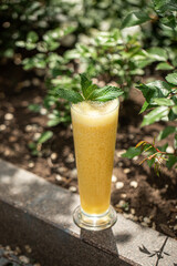 Portion of fresh sweet fruit smoothie with mint in the garden - obrazy, fototapety, plakaty