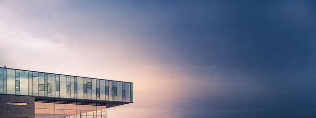 Minimalism in Urban Architecture  Photography. Modern Glass Building Exterior against Dramatic Sky.