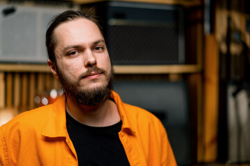 Obraz premium portrait of a rock performer with an electric guitar in a recording studio holds a musical instrument in his hands strings melody